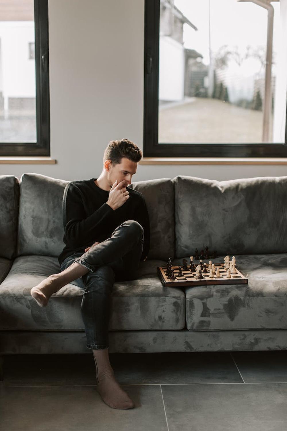 a_man_playing_chess_on_the_couch