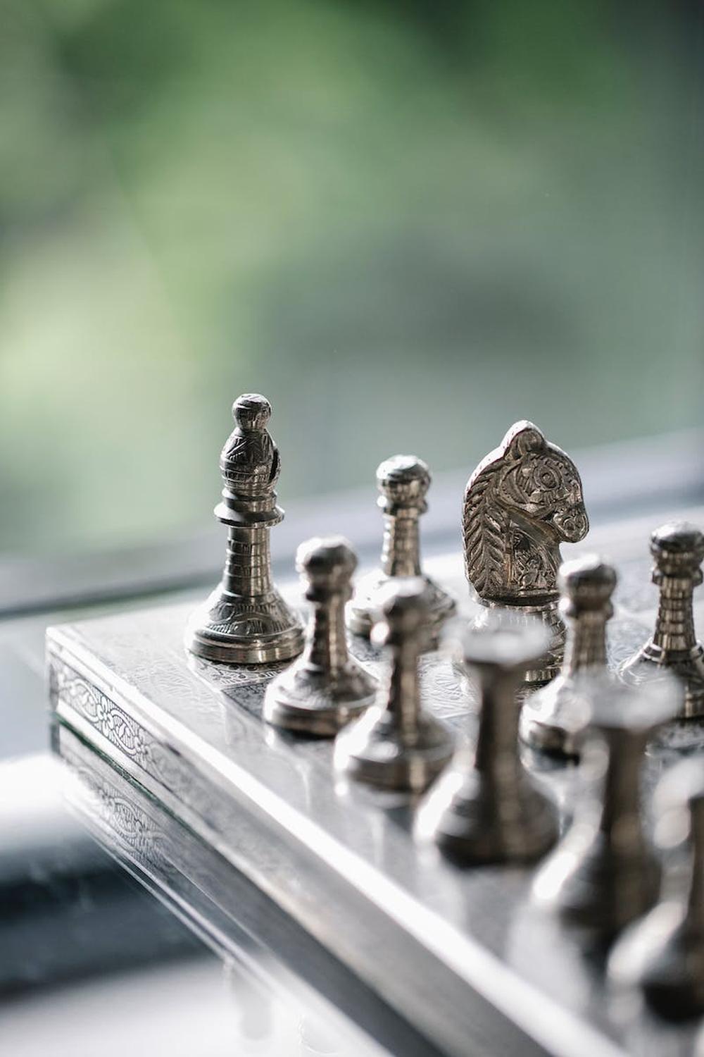 metal_chess_pieces_on_board_in_room